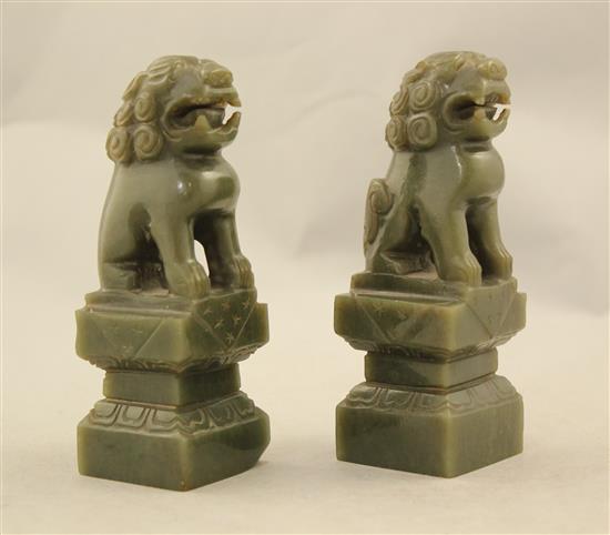 A pair of Chinese spinach green jade lion-dogs and a pair of jadeite figures of elephants, 20th century, 9.5cm, one wood stand